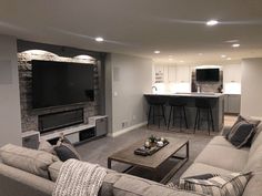 a living room filled with furniture and a flat screen tv mounted on the wall above a fireplace