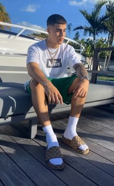 a man sitting on top of a wooden bench next to a boat