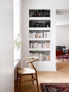 a chair sitting in front of a book shelf filled with books