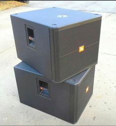 two subwoofers stacked on top of each other in front of a building