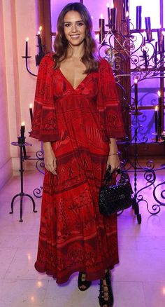 a woman in a red dress posing for the camera