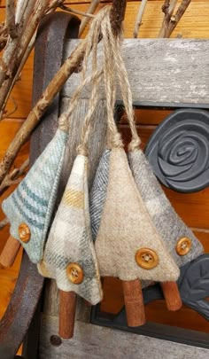 three different colored pieces of fabric hanging from a wooden slatted structure with buttons on them