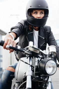 a woman riding on the back of a motorcycle wearing a black leather jacket and helmet