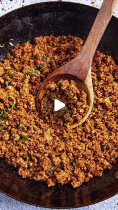 a pan filled with food and a wooden spoon