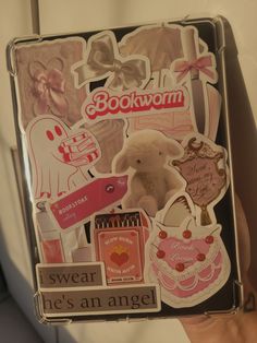 someone is holding up a box with stickers on it that say boowom, swear he's an angel