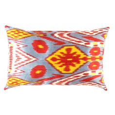 a blue and yellow pillow with an orange design on the front, sitting against a white background