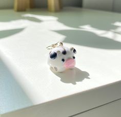 a cow keychain sitting on top of a white table next to a window