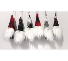 six white and red christmas hats hanging from strings with long, fluffy feathers attached to them