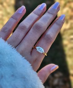 a woman's hand with a ring on it and a diamond in the middle