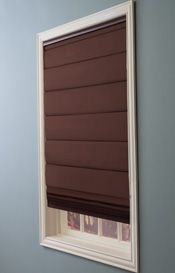 a bathroom with blue walls and brown blinds on the window sill above the toilet