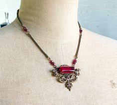 "~ 1940s garnet red glass & bronze necklace ~ Intricate setting with a faceted red glass stone ~ Pendant style necklace with small red glass beads ~ Coil necklace chain ~ Excellent Length- 17\" (43 cm) Pendant Length- 1.5\" (4.5 cm) More Fantastic Vintage Jewelry: glennasvintageshop.etsy.com Additional Vintage in our sister shop Glenna's Jewels: glennasjewels.etsy.com Instagram @glennas_clothing Facebook https://www.facebook.com/glennasclothing" Vintage Red Round Pendant Necklace, Red Ruby Victorian Necklace, 1940s Necklace, Antique Red Necklace With Large Pendant, Unique Red Glass Necklace, Vintage Red Garnet Necklace, Antique Red Garnet Necklace, Garnet Red, Bronze Necklace