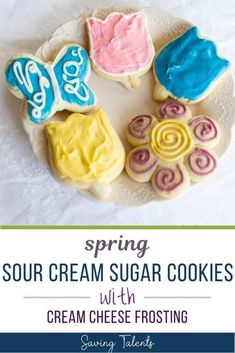 four sugar cookies on a plate with the words spring sour cream sugar cookies with cream cheese frosting