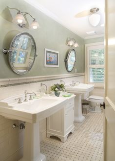 a bathroom with two sinks and three mirrors