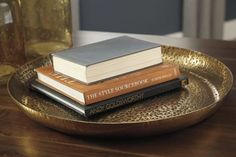 three books are sitting on a gold plate