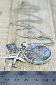 Love to Travel? Know someone going on a holiday? Are you about to leave on that adventure of a lifetime or know someone who is? Commemorate this exciting time with this stunning necklace. Inspired by itchy feet to see the world it features a round America USA Glass map pendant (25mm x 25mm) with plane and passport silver charms, on a exquisite silver ball chain. (Approx 71cm) it makes a thoughtful and unique gift idea. It makes the perfect bon voyage (goodbye/leaving) present for a daughter, gra Personalized Round Pendant Necklace Souvenir, Personalized Round Pendant Necklace As Souvenir, Sterling Silver Round Pendant Jewelry For Travel, Handmade Adjustable Jewelry For Travel, Silver Pendant Jewelry For Travel, Sterling Silver Necklace With Round Pendant For Travel, Vintage Silver Necklace For Travel, Vintage Silver Necklaces For Travel, Personalized Pendant Necklaces For Travel