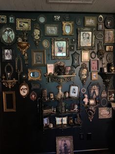 a wall covered in lots of framed pictures and other things on it's side