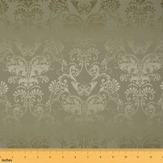 a ruler is next to a wallpaper with an ornate design on it's side