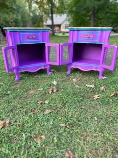 three purple nightstands sitting on top of a grass covered field