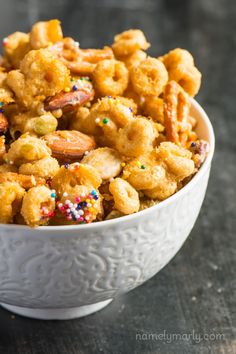 a white bowl filled with cereal and sprinkles on top of a table