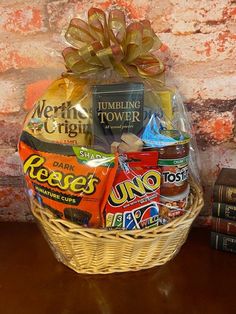 a basket filled with candy and snacks sitting on top of a table next to books