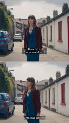 a woman standing on the side of a road next to a blue car and another person walking