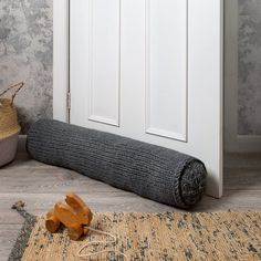 a wooden toy laying on top of a rug next to a white door and some doors