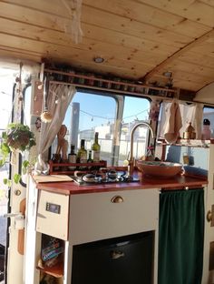 the inside of a camper with a sink, stove and oven on it's side