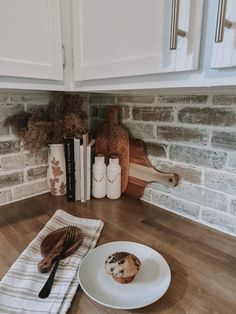 a white plate topped with a muffin on top of a kitchen counter