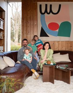 a family sitting on a couch in their living room