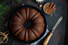 a bundt cake sitting on top of a pan next to some cinnamons and spices