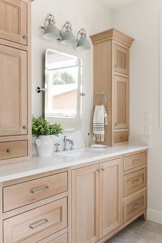 a bathroom with two sinks and wooden cabinets