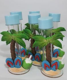 four beach themed glass bottles with palm trees in the sand