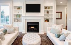 a living room filled with furniture and a fire place in front of a tv mounted on the wall