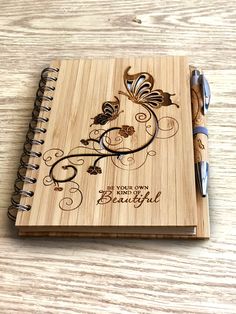 a wooden notebook with an intricate design on the cover and pen resting on top of it