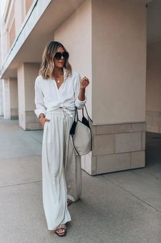 26 Cute Beach Outfit Ideas To Try Out This Summer - MorningKo Beige Wide Pants Outfit Summer, Wide Linen Trousers Outfit, How To Wear Wide Pants Outfit Ideas, Wide White Trousers Outfit, Wide Leg Summer Outfit, Flowy Wide Leg Pants Outfit Work, Wide Leg Pants Button Up Shirt, Creme Wide Leg Pants Outfit, White Pants Wide Leg Outfit