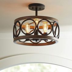 a wooden light fixture with two lights on top of it and an oval design around the base