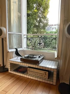 an old record player sitting on top of a table in front of a large window