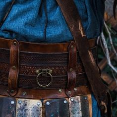 a close up of a person's belt with metal buckles and leather straps