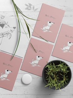 four pink cards with black and white dogs on them next to a potted plant