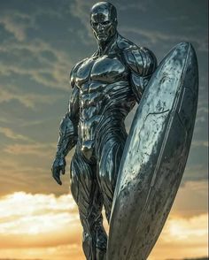 a statue of a man holding a surfboard in front of the sun setting behind him