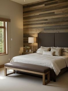 a large bed sitting in a bedroom next to a window with wooden walls behind it