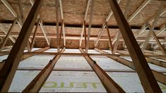 the inside of an unfinished house with straw roofing and wood framing on the floor