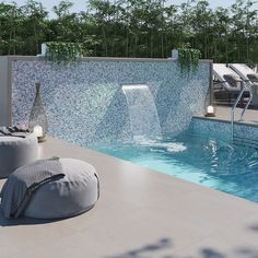 an outdoor pool with lounge chairs and a waterfall