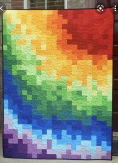 a multicolored quilt on display in front of a door