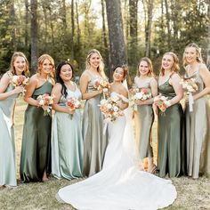 a group of women standing next to each other holding bouquets in front of trees