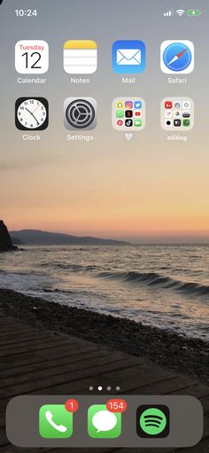 an iphone screen with icons on it next to the ocean