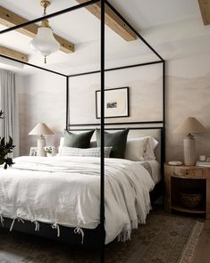 a bed with white sheets and pillows in a room