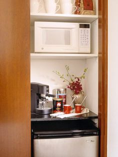 a small kitchen with white cabinets and black counter tops