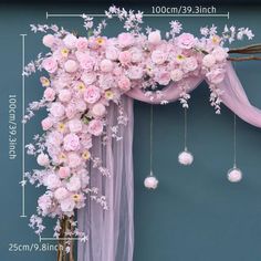 pink flowers are hanging from the side of a wedding arch with pearls and beads on it