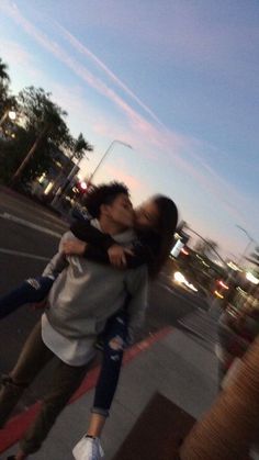 two people hugging each other on the street